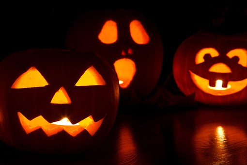 3 citrouilles d'Halloween terrifiantes sculptées et éclairées d'une bougie